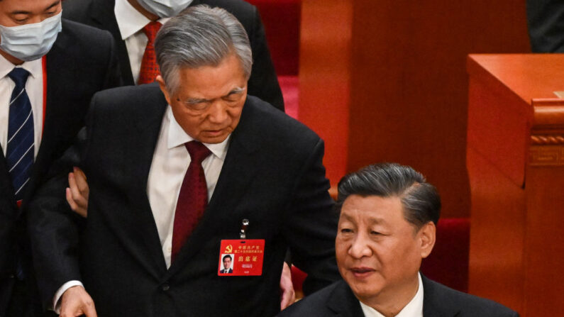 O presidente da China, Xi Jinping, conversa com o ex-presidente Hu Jintao ao sair da cerimônia de encerramento do 20º Congresso do Partido Comunista Chinês no Grande Salão do Povo em Pequim, em 22 de outubro de 2022 (Foto de NOEL CELIS/AFP via Getty Imagens)