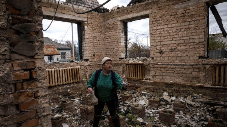 Uma mulher pega enfeites enquanto caminha por sua casa que foi destruída durante as batalhas no início da invasão em grande escala da Rússia, na vila de Yahidne em 30 de outubro de 2022 em Chernihiv, Ucrânia. Quedas de eletricidade e aquecimento em toda a Ucrânia causadas por ataques de mísseis e drones à infraestrutura aumentaram os preparativos de urgência para o inverno. Em 27 de outubro, as tropas russas bombardearam as áreas fronteiriças da região de Chernihiv (Foto de Ed Ram/Getty Images)