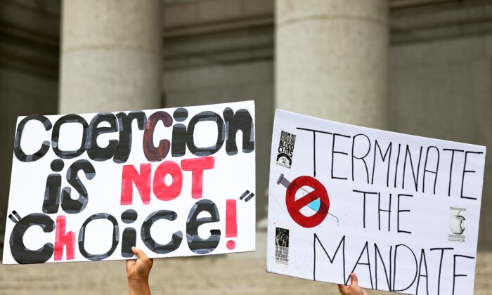 Cartazes de uma manifestação em apoio a um grupo de professores que lutam contra a aplicação do mandato da vacina COVID-19 para funcionários de escolas públicas no Thurgood Marshall Tribunal dos Estados Unidos, em Nova Iorque, em 12 de outubro de 2021 ( Michael M. Santiago/Getty Images)
