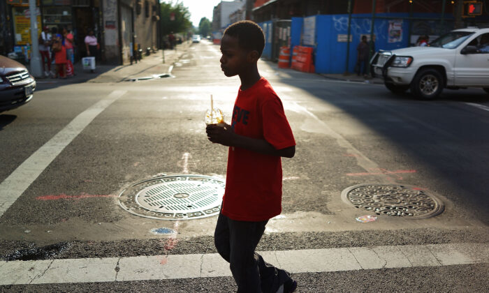 Um menino caminha por uma rua no bairro de Brooklyn, em Nova Iorque, em 23 de julho de 2013 (Spencer Platt/Getty Images)