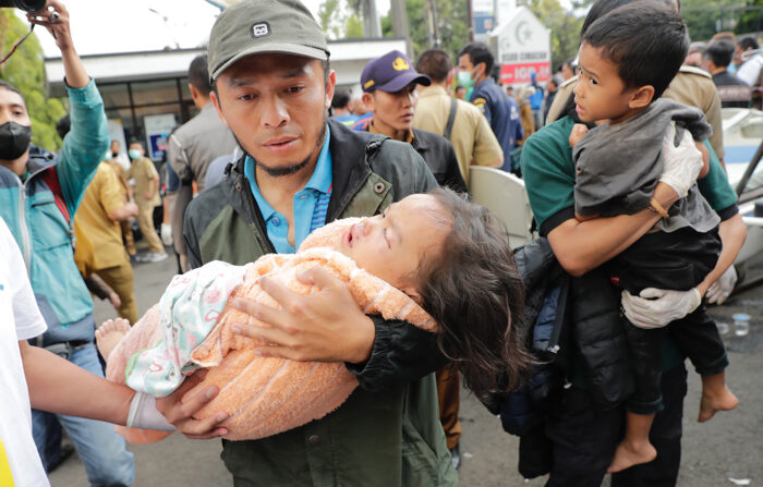 Cianjur (Indonésia), 21/11/2022.- Socorristas e uma mãe carregam o corpo de um menino, vítima do terremoto que atingiu Cianjur, na Indonésia ( EFE/EPA/ADI WEDA)
