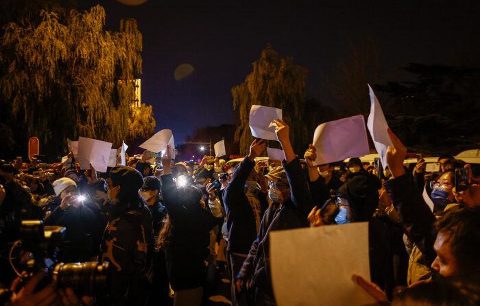 Manifestantes agitam papéis brancos em protesto em Pequim, após incêndio em Urumqi que matou 10 pessoas (EFE/EPA/MARK R. CRISTINO)