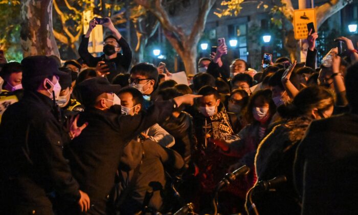 A polícia e as pessoas são vistas em confronto durante um protesto contra a política de COVID-zero da China em Xangai, em 27 de novembro de 2022. (Hector Retamal/AFP via Getty Images)