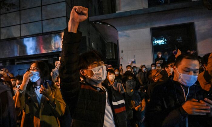 Pessoas cantam enquanto se reúnem em uma rua em Xangai em 27 de novembro de 2022 (Hector Retamal/AFP via Getty Images)