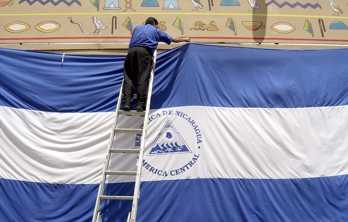 Um funcionário do Casino Pharaos de Manágua instala uma gigantesca bandeira da Nicarágua por ocasião da celebração do 182º Aniversário da Independência. (EFE/Arquivo/Oscar Navarrete)