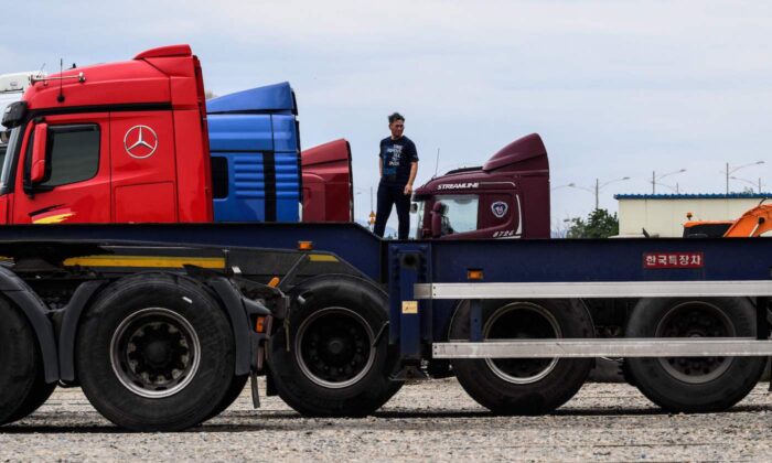 Um homem está entre caminhões estacionados como parte de uma greve em um estacionamento perto de um porto de contêineres em Incheon, na Coreia do Sul em 14 de junho de 2022, no oitavo dia de um protesto contra o aumento dos custos de combustível que tem prejudicado ainda mais as cadeias de suprimentos globais (Anthony Wallace/AFP via Getty Images)