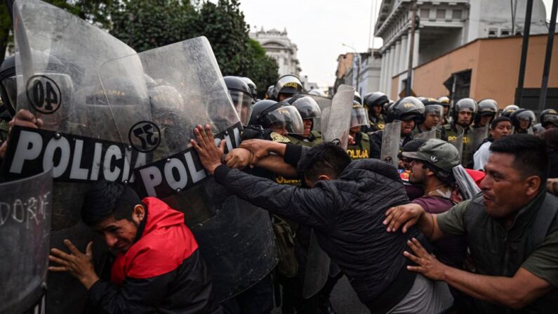 Pessoas entram em confronto com a tropa de choque durante uma manifestação exigindo a libertação do ex-presidente, Pedro Castillo, e o fechamento do Congresso peruano, em Lima, em 8 de dezembro de 2022, um dia após o impeachment de Castillo (Foto de ERNESTO BENAVIDES/AFP via Getty Images)