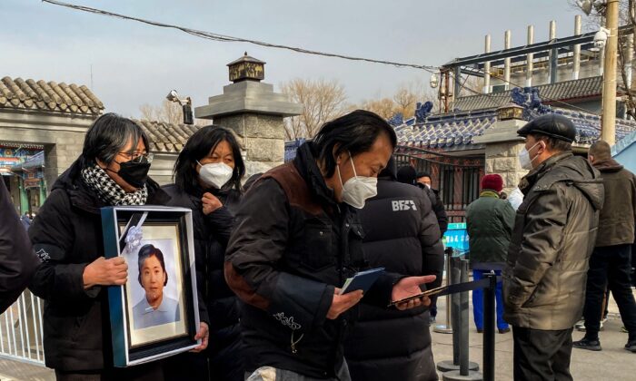 Parentes carregam um porta-retrato de um ente querido em um crematório em Pequim em 20 de dezembro de 2022. (Noel Celis/AFP via Getty Images)