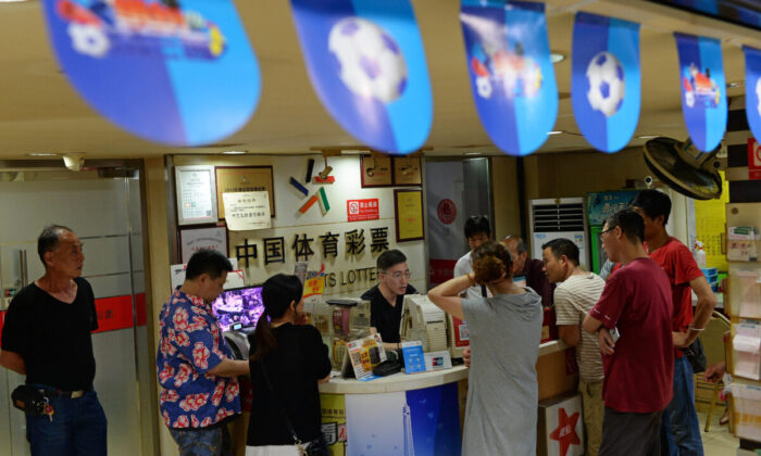 Pessoas comprando bilhetes de loteria em uma loja da China Sports Lottery em Xangai, China, em 2 de julho de 2018 (AFP via Getty Images)