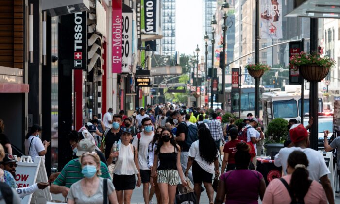 pessoas caminham por uma área comercial em Manhattan, na cidade de Nova York, em 7 de junho de 2021. (Angela Weiss/Getty Images)