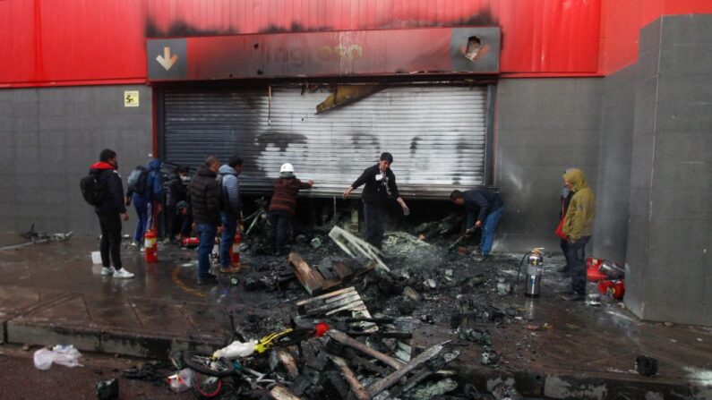 Funcionários de supermercados inspecionam os danos causados pelo incêndio após confrontos entre a tropa de choque e manifestantes antigovernamentais em Puno, Peru, em 9 de janeiro de 2023 militares, disseram autoridades. A violência ocorreu na cidade de Juliaca, no sudeste do país, na região de Puno, disse à AFP um funcionário da ouvidoria local (Foto de JUAN CARLOS CISNEROS / AFP via Getty Images)