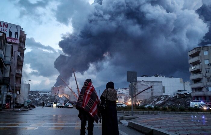 Duas pessoas observam os danos causados ​​pelos terremotos em Hatay, na Turquia, na terça-feira. Os dois terremotos que abalaram o sudeste da Turquia e o norte da Síria (EFE/Erdem Sahin)