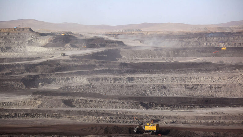 Esta foto tirada em 15 de novembro de 2010 mostra trabalhadores dirigindo caminhões em uma mina de carvão em Huo Lin Guo Le, região norte da Mongólia Interior da China (Foto GOU YIGE/AFP via Getty Images)