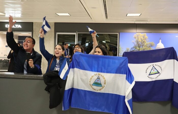 Pessoas seguram bandeiras da Nicarágua aguardando a chegada dos presos políticos expulsos daquele país, hoje no aeroporto de Dulles, Virgínia (EUA) (EFE/Octavio Guzmán)