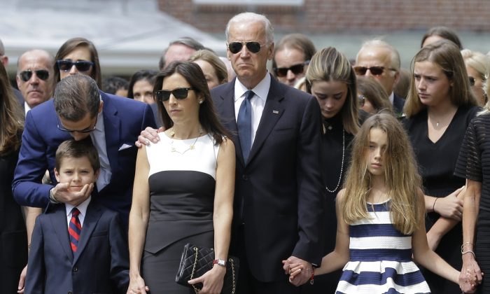 Hunter Biden (esquerda) beija seu sobrinho Hunter, filho de Beau Biden, enquanto eles ficam com a viúva de Hallie Beau, o então vice-presidente Joe Biden e a filha de Beau, Natalie, antes de seu funeral, na Igreja Católica Romana de Santo Antônio de Pádua em Wilmington, Del., em 6 de junho de 2015 (Patrick Semansky/AP Photo)