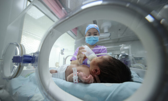 Uma equipe médica alimenta um bebê em um hospital em Danzhai, na província de Guizhou, no sudoeste da China, em 11 de maio de 2021 (STR/AFP via Getty Images)