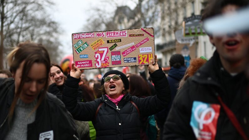 Um manifestante segura uma faixa com os dizeres "Vamos defender nossas pensões" durante uma manifestação, como parte de um dia nacional de greves e protestos convocados por sindicatos contra a proposta de reforma das pensões, em Paris, em 11 de março de 2023 (Foto de CHRISTOPHE ARCHAMBAULT / AFP via Getty Images)