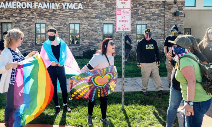 Ativista pró-direitos de gênero (esquerda) enfrenta manifestantes que estão contra Christynne Wood, uma mulher trans que foi criticada por usar o vestiário feminino no YMCA, em Santee, uma cidade suburbana no condado de San Diego, Califórnia, em 21 de janeiro de 2023 (Foto de SANDY HUFFAKER / AFP via Getty Images)