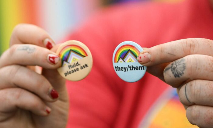 Um ativista segura alfinetes sobre pronomes de gênero no campus da Universidade de Wyoming em Laramie, Wyoming, em 13 de agosto de 2022. (Patrick Fallon/AFP via Getty Images)