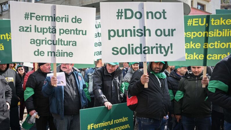 Agricultores romenos protestam em frente à sede da Comissão Europeia em Bucareste, em 7 de abril de 2023. - Agricultores se reúnem em um protesto nacional contra a compensação insuficiente recebida dos fundos da UE após a eliminação completa dos direitos aduaneiros sobre todos os produtos da Ucrânia desde a meados do ano passado (Foto de DANIEL MIHAILESCU/AFP via Getty Images)