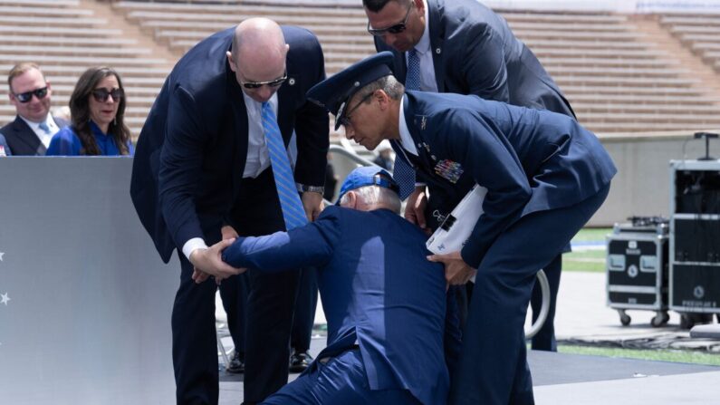 O presidente Joe Biden é ajudado após cair durante a cerimônia de formatura na Academia da Força Aérea dos EUA, perto de Colorado Springs, no condado de El Paso, Colorado, em 1º de junho de 2023 (Brendan Smialowski/AFP via Getty Images)