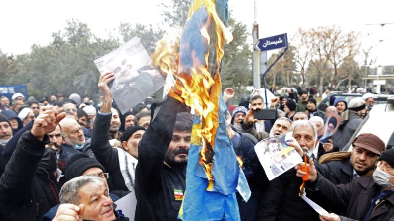 Iranianos queimam uma bandeira sueca durante protesto em Teerã em 27 de janeiro de 2023 contra a queima de um Corão em Estocolmo (Foto de STR/AFP via Getty Images)