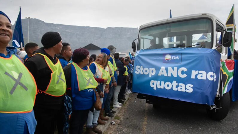 Um caminhão com uma faixa lidera apoiadores da Aliança Democrática, o principal partido de oposição da África do Sul, enquanto marcham pelas ruas da cidade para protestar contra a nova proposta do Congresso Nacional Africano de cotas de emprego em linhas raciais, na Cidade do Cabo, em 26 de julho de 2023 (Rodger Bosch/AFP via Getty Images)