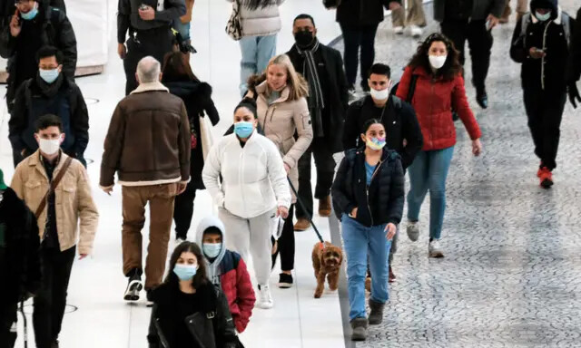 Pessoas usam máscaras em um shopping coberto no The Oculus, na parte baixa de Manhattan, no dia em que um mandato de máscara entrou em vigor em Nova Iorque , em 13 de dezembro de 2021. (Spencer Platt/Getty Images)