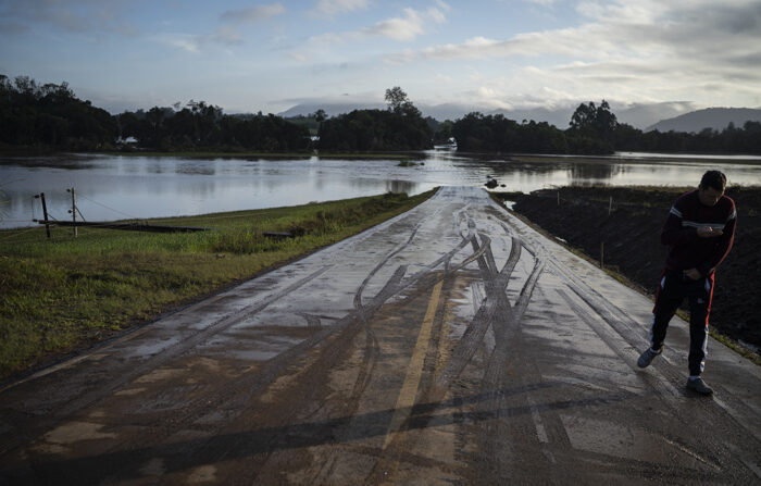 Um habitante caminha hoje por uma estrada inundada pelas fortes chuvas pela passagem de um ciclone, na cidade de Roca Sales, Rio Grande do Sul (EFE/Daniel Marenco)