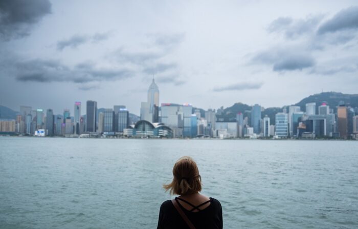 Uma mulher olha para o horizonte de Hong Kong enquanto o tufão 'Saola' se aproxima em Hong Kong, China, na sexta-feira. O governo de Hong Kong ordenou que a administração se preparasse para “o pior cenário possível” antes da aproximação do Supertufão Saola e anunciou a suspensão da sua bolsa e o encerramento de escolas e de alguns negócios a partir desta sexta-feira (EFE/ Bertha Wang)