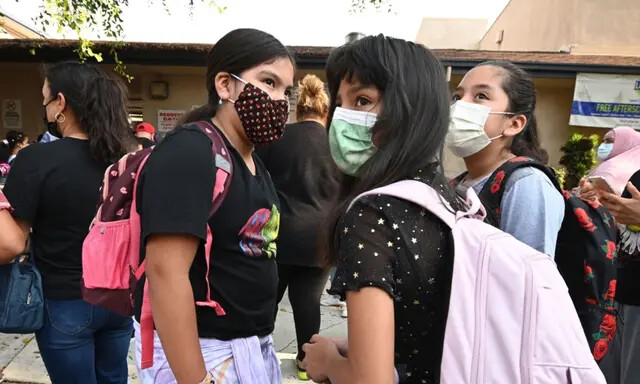 Alunos e pais chegam mascarados para o primeiro dia do ano letivo na Grant Elementary School em Los Angeles, Califórnia, em 16 de agosto de 2021. (Robyn Beck/AFP via Getty Images)