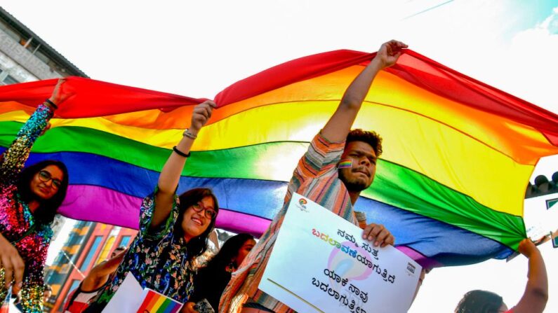 Membros e apoiadores de lésbicas, gays, bissexuais e transgêneros (LGBT) seguram uma bandeira do arco-íris enquanto participam de uma parada anual do orgulho organizada pela Coalizão dos Direitos dos Trabalhadores do Sexo e das Minorias Sexuais e Sexuais (CSMR) em Bangalore, em novembro. 24 de outubro de 2019 (Foto de MANJUNATH KIRAN/AFP via Getty Images)