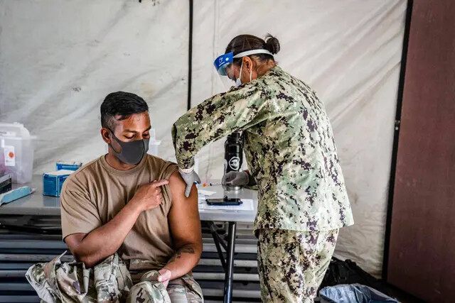 Um membro das forças armadas dos EUA recebe a vacina Moderna contra a COVID-19 em Camp Foster em Ginowan,  Japão, em 28 de abril de 2021 (Carl Court/Getty Images)
