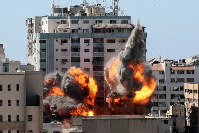 Uma bola de fogo irrompe da Torre Jala quando ela é destruída em um ataque aéreo israelense contra alvos do Hamas na cidade de Gaza, que é controlada pelo grupo terrorista Hamas, em 15 de maio de 2021 (Mahmud Hams/AFP via Getty Images)
