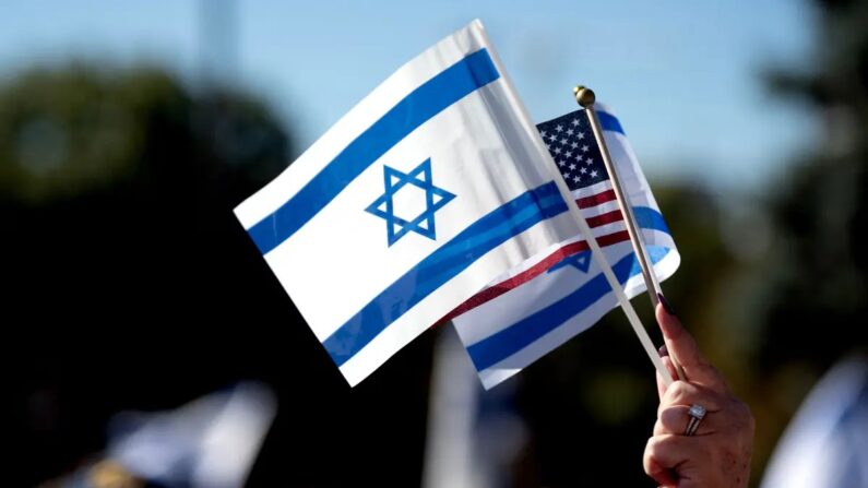 Um manifestante segura as bandeiras de Israel e dos Estados Unidos durante uma manifestação em apoio a Israel fora do Capitólio do Estado do Colorado, em Denver, Colorado, em 15 de outubro de 2023. (Jason Connolly/AFP via Getty Images)