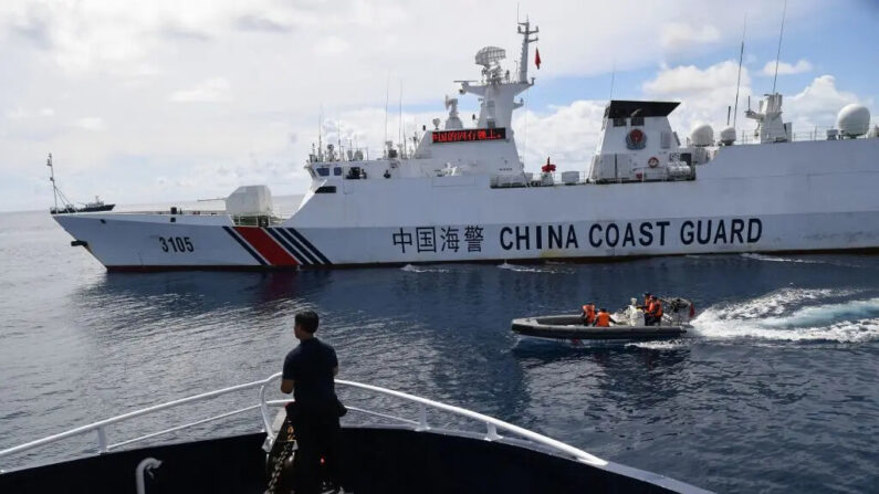 Esta foto tirada em 22 de setembro de 2023 mostra um navio da guarda costeira chinesa (direita) bloqueando um navio (esquerda) do Bureau de Pesca e Recursos Aquáticos das Filipinas (BFAR) enquanto seu pessoal a bordo de um barco inflável de casco rígido navegava pelo navio filipino ao se aproximar de Scarborough Shoal, controlado pelos chineses, no disputado Mar da China Meridional (Ted Aljibe/AFP via Getty Images)
