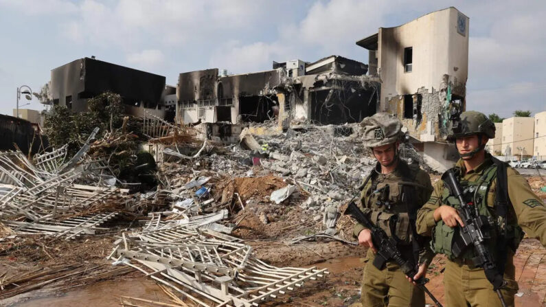 Soldados caminham em frente a uma delegacia de polícia israelense que foi danificada durante as batalhas para desalojar terroristas do Hamas em 8 de outubro de 2023 (Jack Guez/AFP via Getty Images)