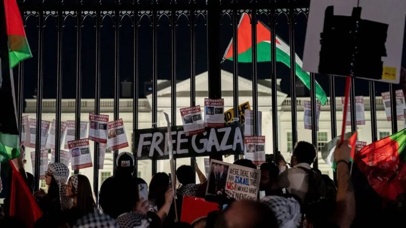 Manifestantes exibem cartazes na cerca da Casa Branca durante um comício pró-Palestina em Washington, em 4 de novembro de 2023. (Stefani Reynolds/AFP via Getty Images)
