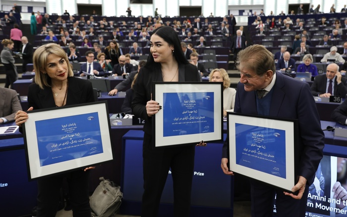 Os ativistas iranianos Mersedeh Shahinkar (esq.) e Afsoon Najafi, e Saleh Nikbakht, advogado que representa a família de Mahsa Amini, durante a cerimônia de entrega do Prêmio Sakharov no Parlamento Europeu em Estrasburgo, França, em 12 de dezembro de 2023 (EFE/RONALD WITTEK)