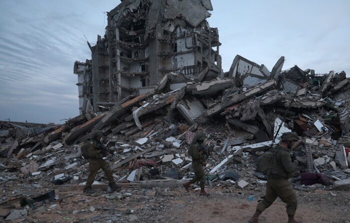 Foto de arquivo de soldados israelenses caminhando entre os escombros de edifícios destruídos na cidade palestina de Beit Lahia (EFE/EPA/ATEF SAFADI).