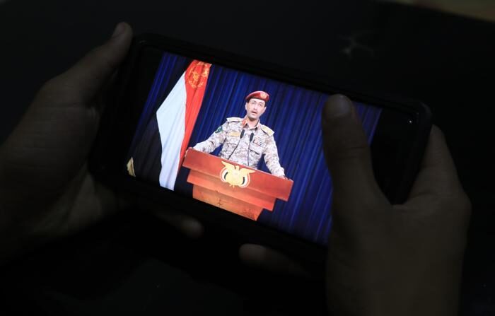 Uma pessoa olha para o porta-voz militar houthi Yahya Sarea em um telefone celular (EFE/EPA/YAHYA ARHAB)