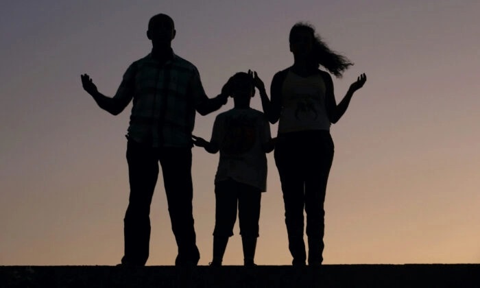 Uma família cristã ora em uma foto de arquivo. (Patrick Baz/AFP via Getty Images)
