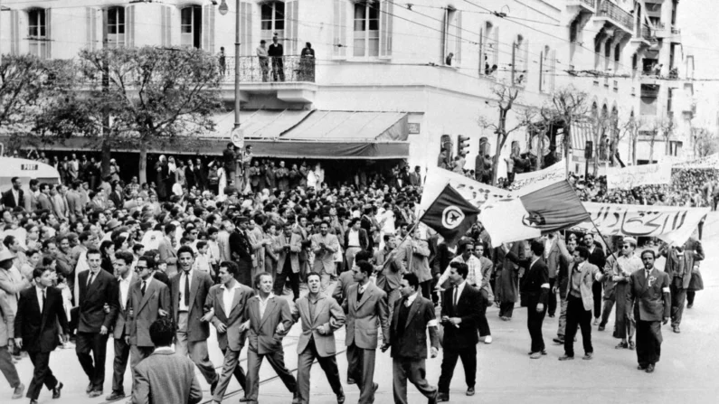Manifestantes apoiando a independência da Argélia da França desfilam pelas ruas de Túnis em 1º de maio de 1956. Entre os teóricos fundadores da descolonização, central está o psiquiatra franco-caribenho Frantz Fanon, escreve Brock Eldon (-/AFP via Getty Images)