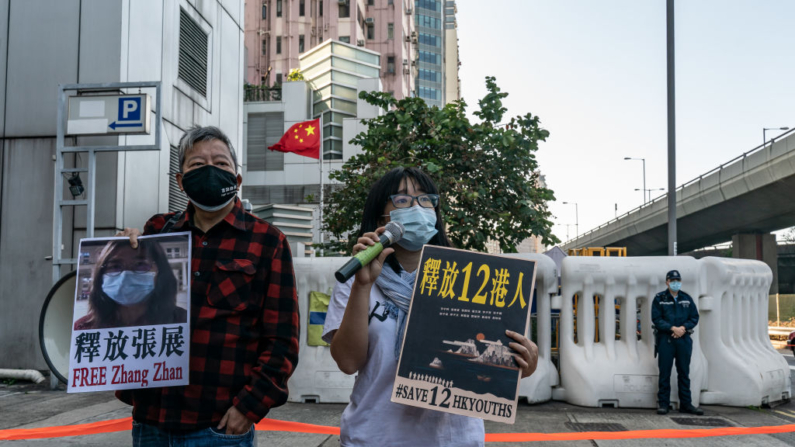Ativistas pró-democracia seguram cartazes enquanto demonstram apoio aos doze residentes de Hong Kong detidos na China continental e ao ex-advogado Zhang Zhan do lado de fora do Escritório de Ligação do Governo Popular Central em 28 de dezembro de 2020 em Hong Kong, China (Foto de Anthony Kwan/Getty Images)