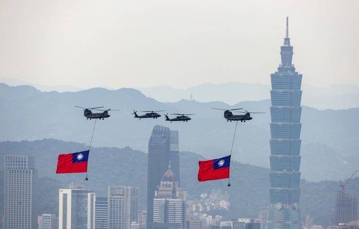 Helicópteros Chinook da Força Aérea de Taiwan carregam bandeiras nacionais enquanto realizam um sobrevoo durante um ensaio antes da posse do presidente eleito William Lai em Taipei, Taiwan, em 17 de maio de 2024 (EFE/EPA/RITCHIE B. TONGO)
