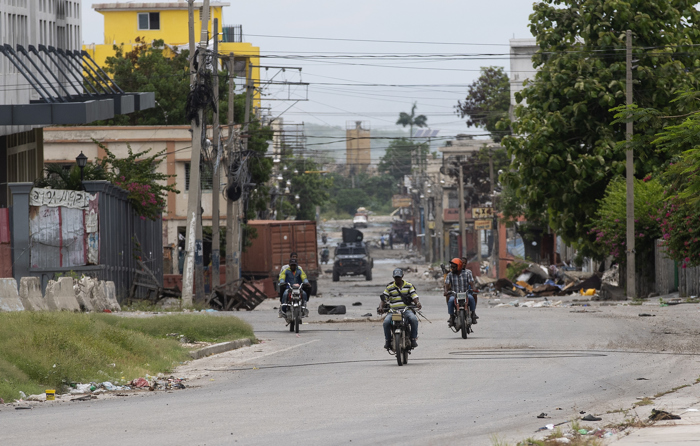 Motociclistas circulam em alta velocidade quando ouvem rafagas nas ruas próximas ao bairro Bel Air em Puerto Príncipe (Haití). EFE/ Orlando Barria