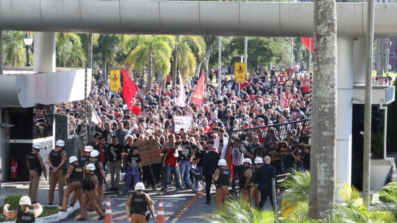 Minutos antes das 14h30, horário regimental da sessão, os manifestantes já estavam nas galerias quando a multidão forçou a entrada, rompendo o portão de acesso a carros da Assembleia e, em seguida, invadindo o Prédio do Plenário. (Créditos: Orlando Kissner/Alep)
