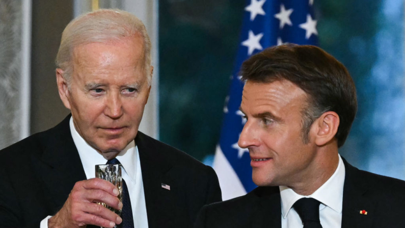 O presidente dos EUA, Joe Biden, olha para o presidente da França, Emmanuel Macron, enquanto eles fazem brindes durante um jantar oficial de Estado como parte da visita de Estado do presidente dos EUA à França, no Palácio Presidencial do Eliseu, em Paris, em 8 de junho de 2024 (Foto de SAUL LOEB/AFP via Getty Images)