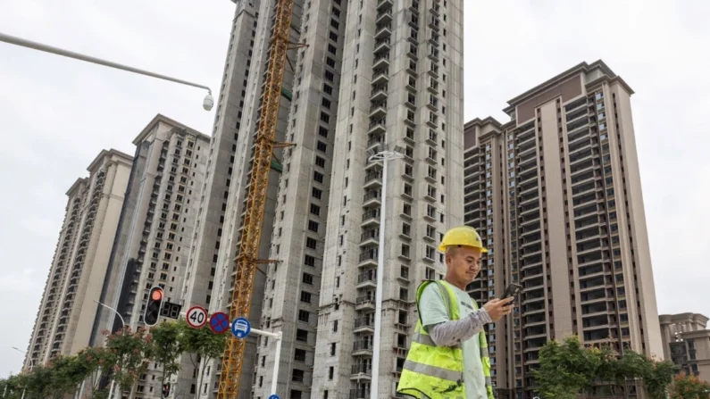 Um trabalhador passa por um complexo habitacional em construção pela incorporadora chinesa Evergrande em Wuhan, na província central de Hubei, na China, em 28 de setembro de 2023. (STR/AFP via Getty Images)
