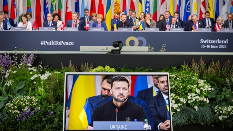 O presidente da Ucrânia, Volodymyr Zelensky, é visto em uma tela durante uma sessão plenária da Cúpula sobre a paz na Ucrânia, no luxuoso resort Burgenstock, perto de Lucerna, em 16 de junho de 2024 (Foto: URS FLUEELER/POOL/AFP via Getty Images)
